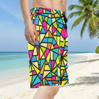 Guy wearing colorful geometric patterned shorts on a tropical island beach.