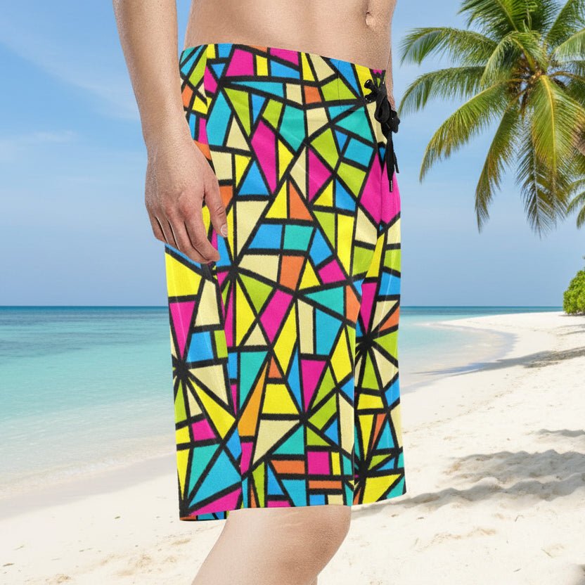 Guy wearing colorful geometric patterned shorts on a tropical island beach.