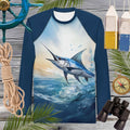 Navy blue long-sleeve rash guard with marlin design on a wooden background with nautical items.