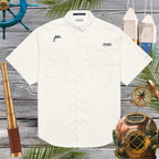 White shirt with embroidered dolphin logo on a wooden background with nautical items
