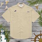 Beige short-sleeve shirt with shark embroidery over a wooden background with decorative sea elements.
