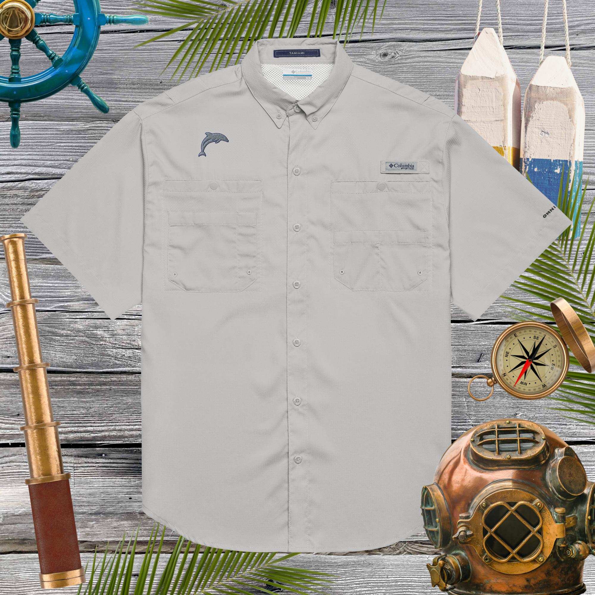 Light gray shirt with a dolphin emblem on a wooden background with vintage nautical diving helmet a compass and a spyglass 