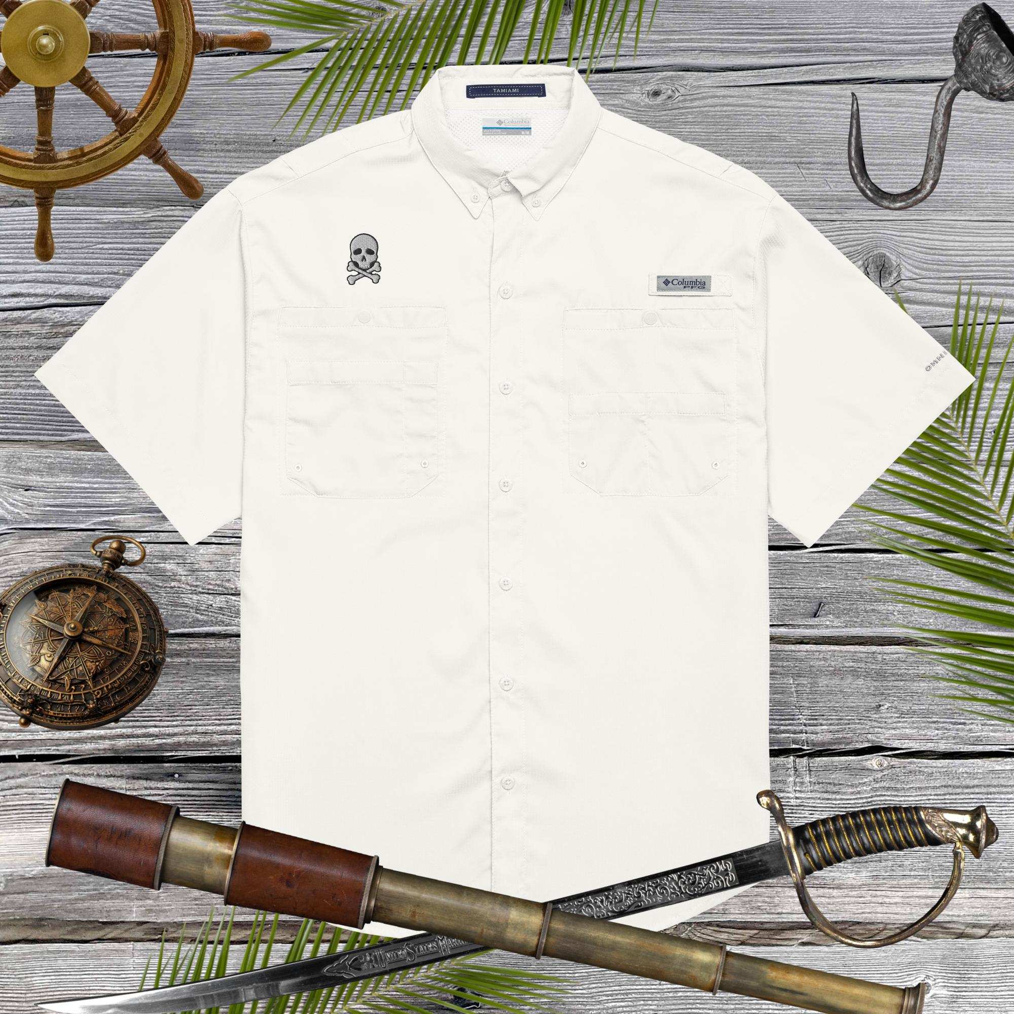 White shirt with embroidered skull design on a wooden background with nautical items