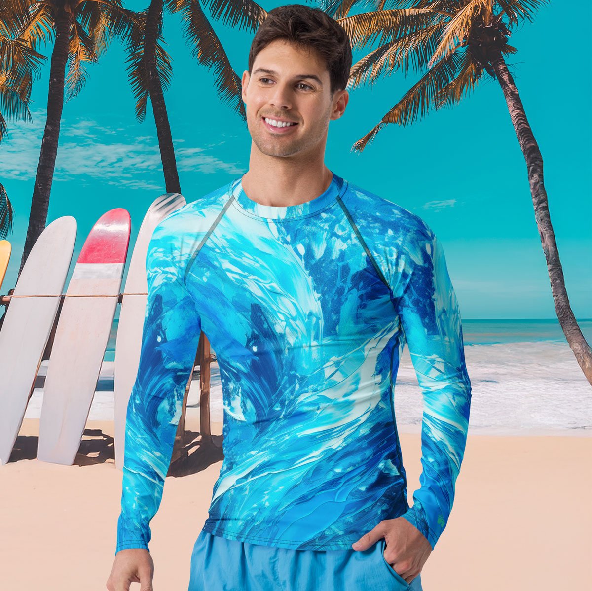 Man wearing a blue patterned long sleeve rash guard  on a beach with palm trees and surfboards in the background