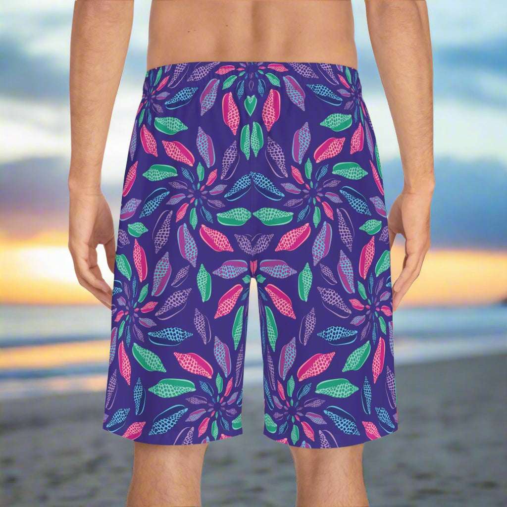 Backside of Men's Junonia Pattern Board-shorts as worn by sheller searching for rare seashells on an empty beach at sunrise.