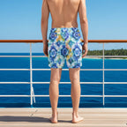dude wearing tie-dye swim shorts with a drawstring looking out at a tropical island from the deck of a cruise ship