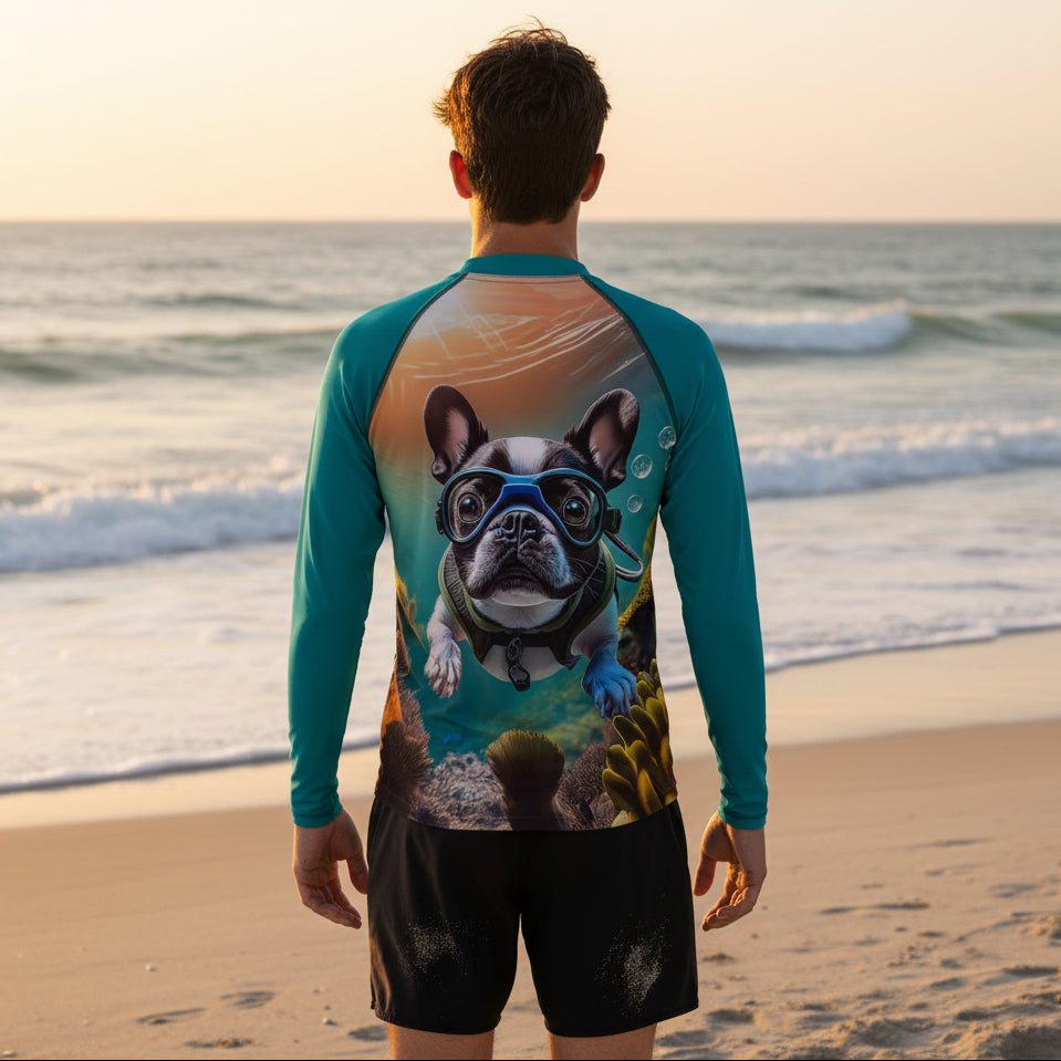 Dude standing on Naples Beach facing the ocean, wearing a long-sleeve swim shirt with a colorful graphic print of a French bulldog underwater on the back, paired with black swim shorts.