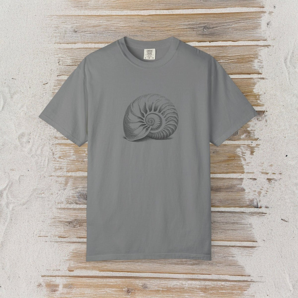 A gray short-sleeve crewneck t-shirt featuring a dark gray spiral ammonite shell graphic on the chest, displayed flat against a rustic light wood plank background.