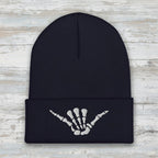 dark navy beanie with shaka skeleton hand embroidered on the cuff on a rustic wood background