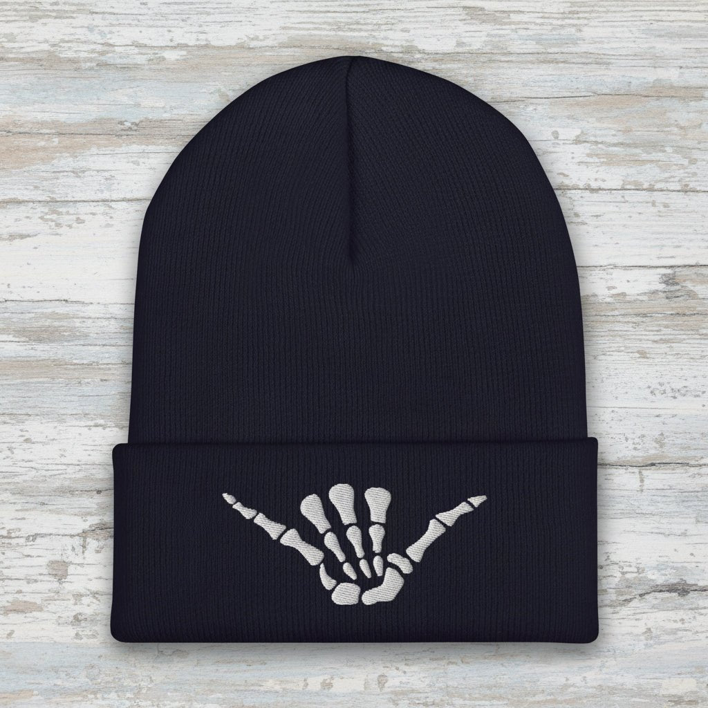 dark navy beanie with shaka skeleton hand embroidered on the cuff on a rustic wood background