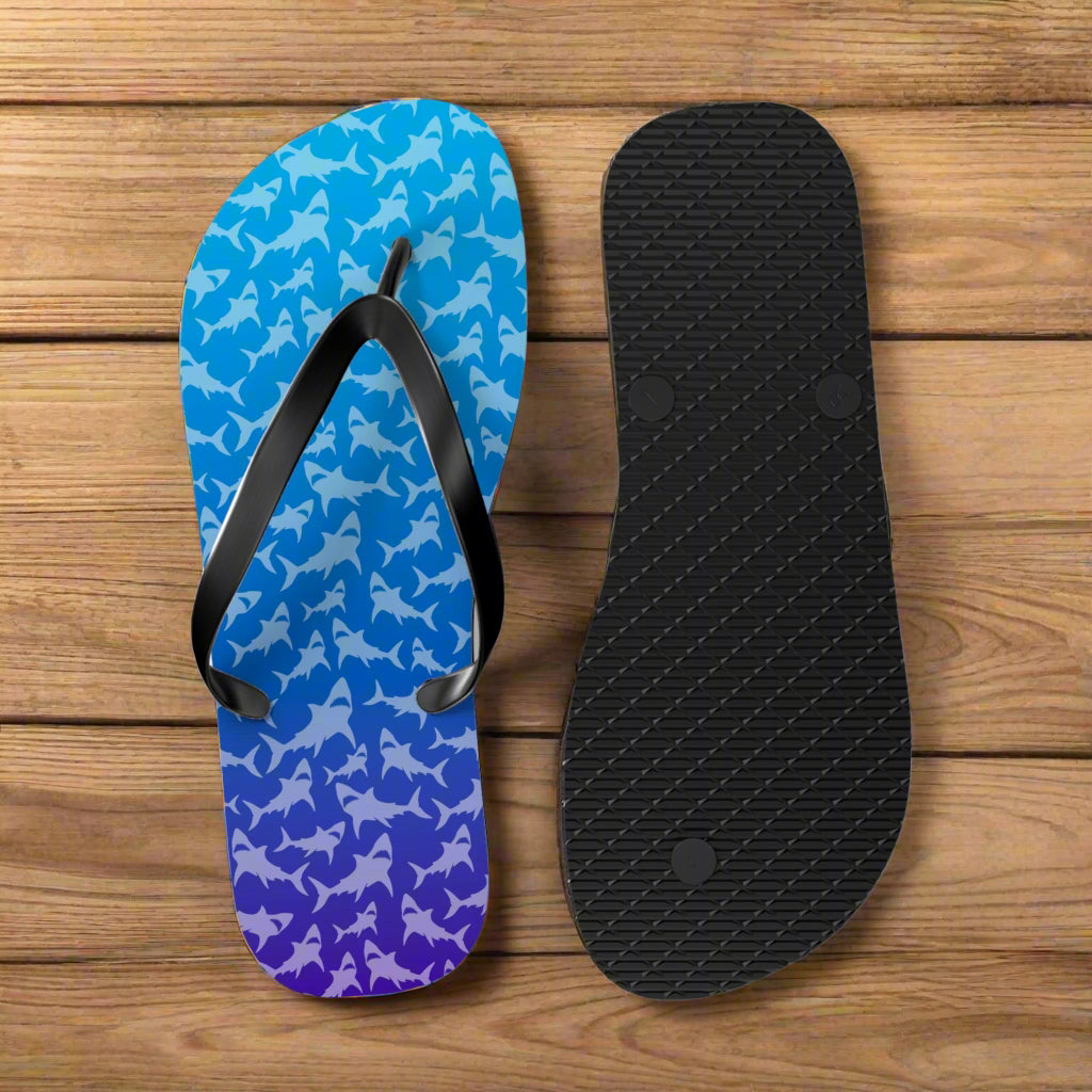 Blue ombre shark pattern flip-flop with black insole on a rustic nautical wood background