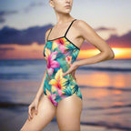 Sexy woman wearing a cute one piece swimsuit with Hawaiian flowers is standng in the ocean next to the shore