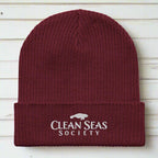 Organic Burgundy Beanie with Clean Seas Society logo over nautical wood