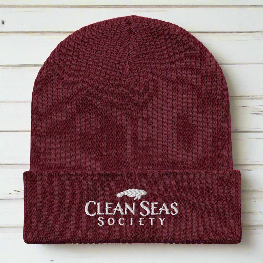Organic Burgundy Beanie with Clean Seas Society logo over nautical wood