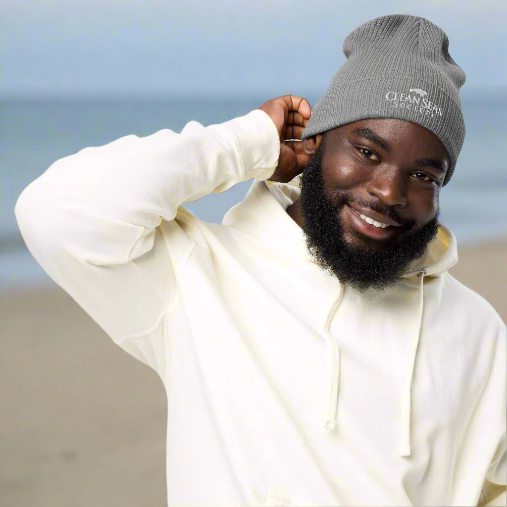 Dude wearing an organic Beanie with Clean Seas Society logo joining local Beach Cleaning Party
