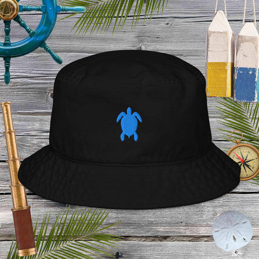 Black bucket hat with a blue turtle logo on a wooden background with nautical items.