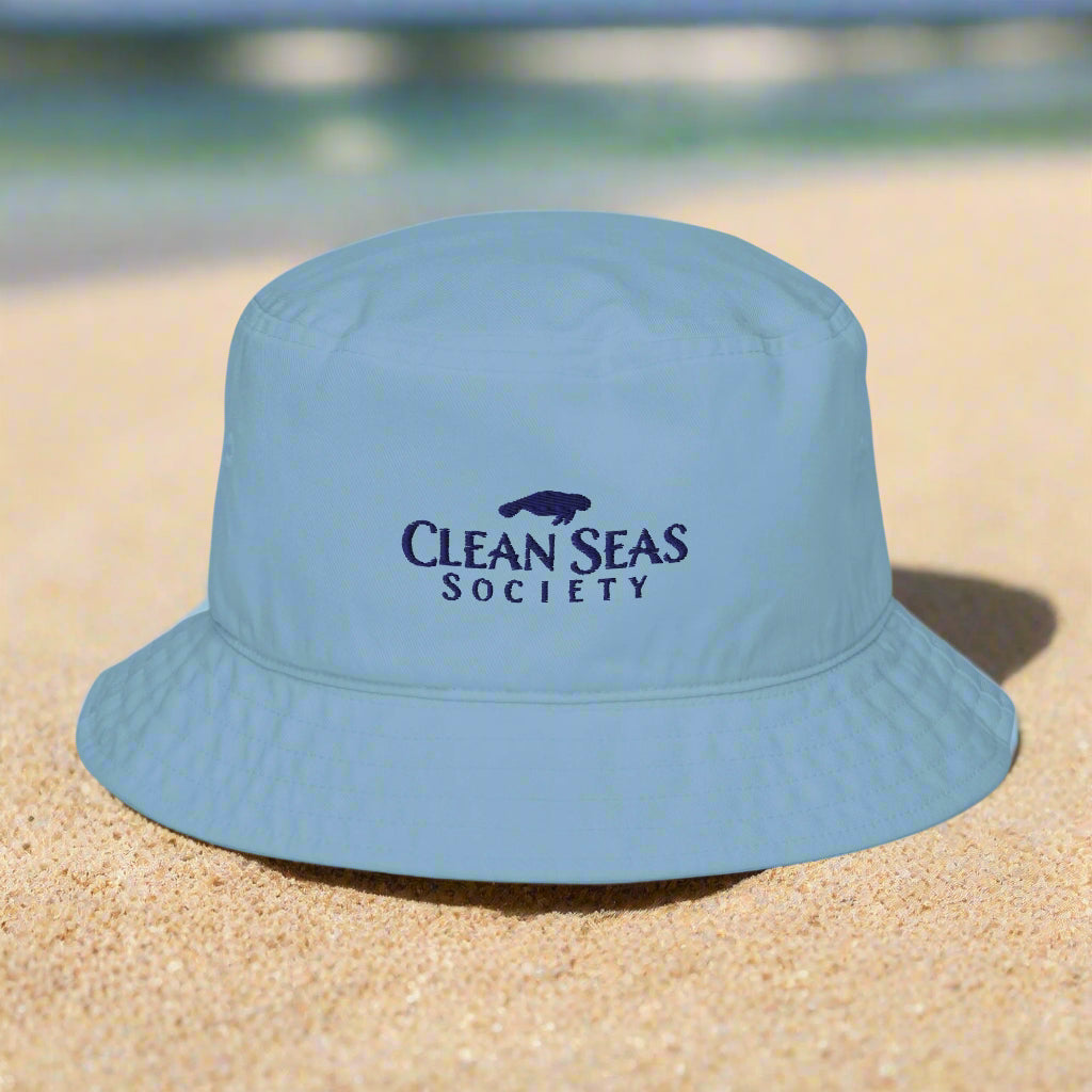 Clean Seas Society Organic Bucket Hat sitting in clean white sand