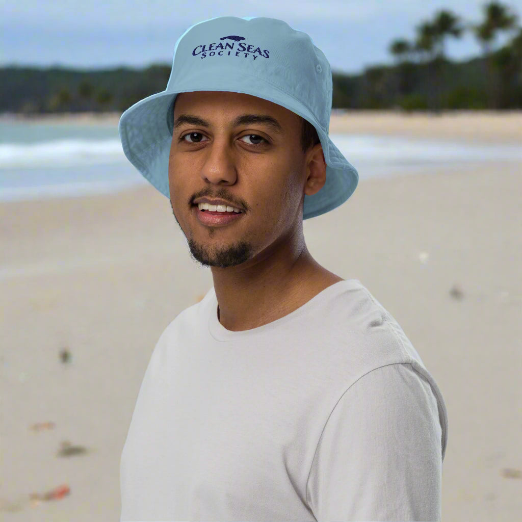 Dune in a slate blue Organic Bucket Hat with Clean Seas Society logo doing his part at a local beach cleaning party