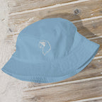 Blue bucket hat with a logo on a wooden surface