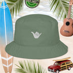 Green bucket hat with a embroidered white shaka symbol on a background with a surfboard, ukulele, and vintage car.