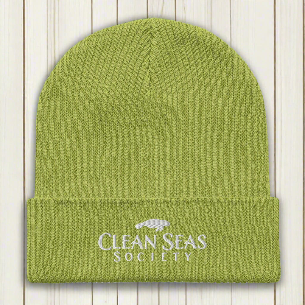 Leaf Green Organic Beanie with Clean Seas Society Logo on a nautical wood background