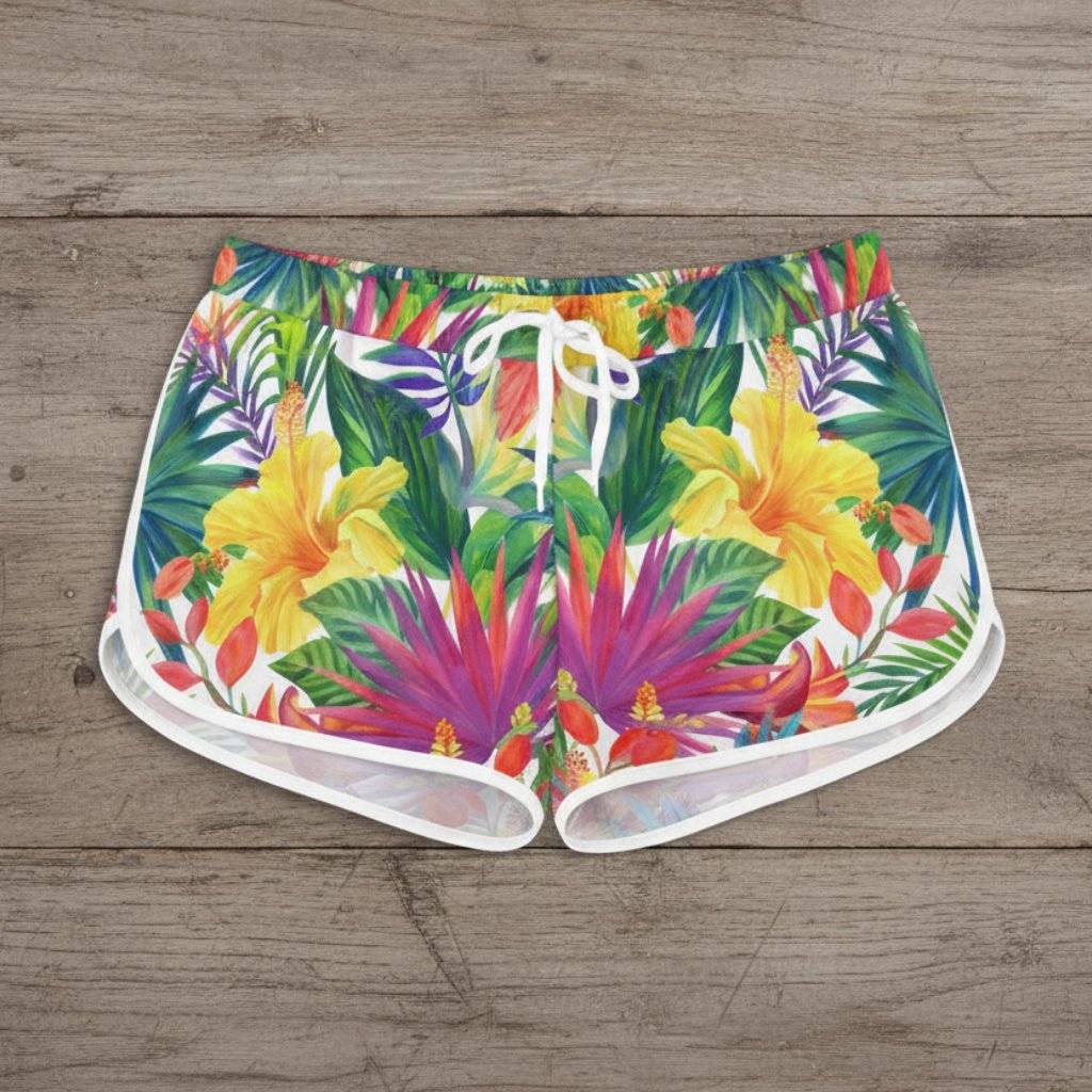 Colorful tropical print shorts worn by a person on a white background