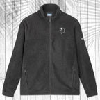 A dark gray fleece zip-up jacket with a stand collar, shown flat against a white wood plank background with a palm leaf pattern overlay. The jacket features a small white circular logo on the left chest and a small white logo on the right sleeve.