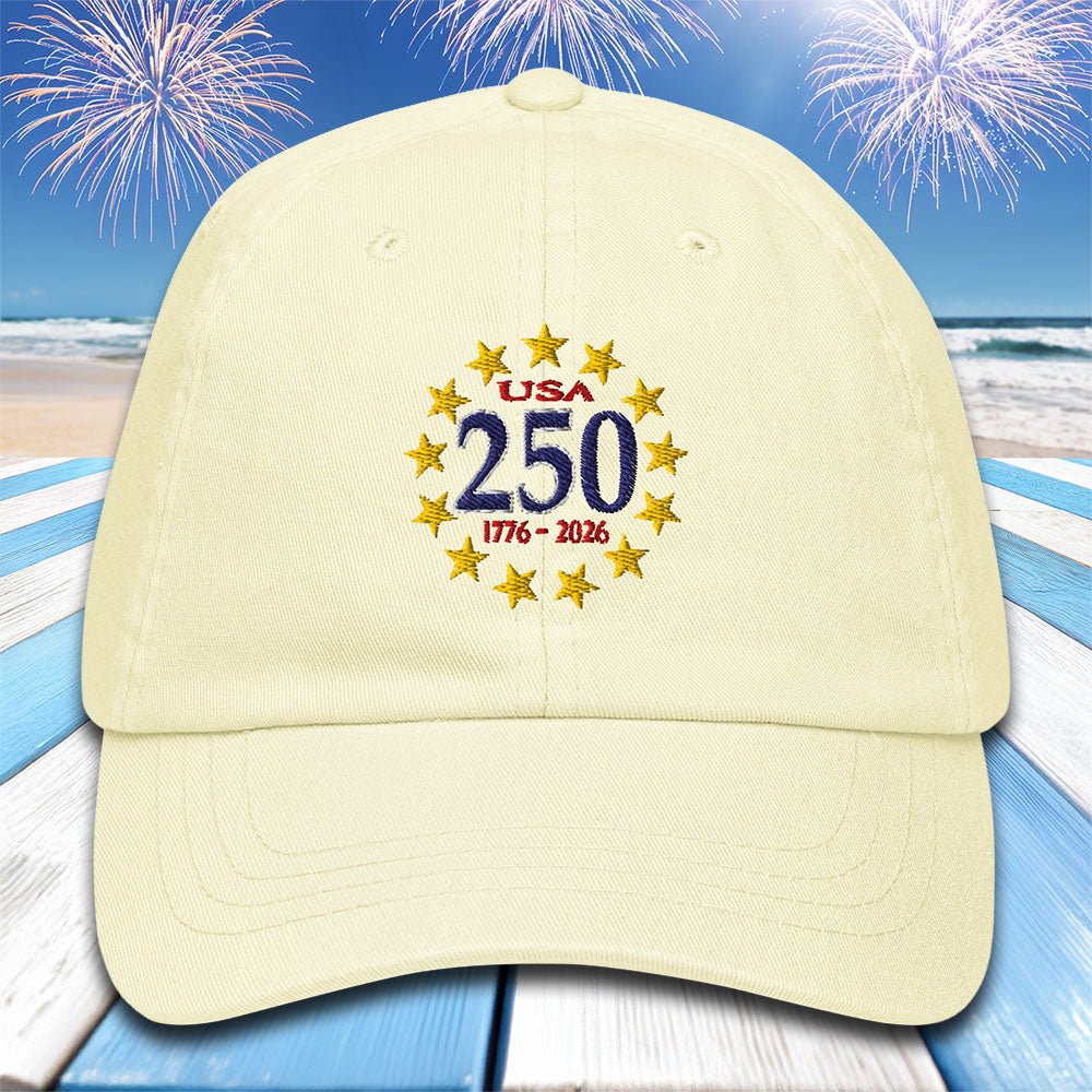 Pastel lemon cap with 'USA 250' text and star design on a beach with fireworks background
