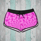 Pink shark pattern shorts with black drawstring on a rustic wood background