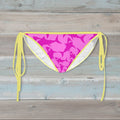 Pink Shark pattern bikini bottom with yellow straps on a rustic wood background