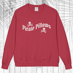 A red crewneck sweatshirt with 'Pirate Pillows' and skull-and-crossbones graphics on the chest, displayed flat against a white wood plank background.
