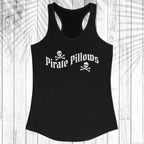 A black racerback tank top with 'Pirate Pillows' and skull-and-crossbones graphics on the front, displayed flat against a white wood plank background.