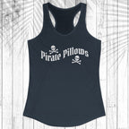 A black racerback tank top with 'Pirate Pillows' and skull-and-crossbones graphics on the front, displayed flat against a white wood plank background.