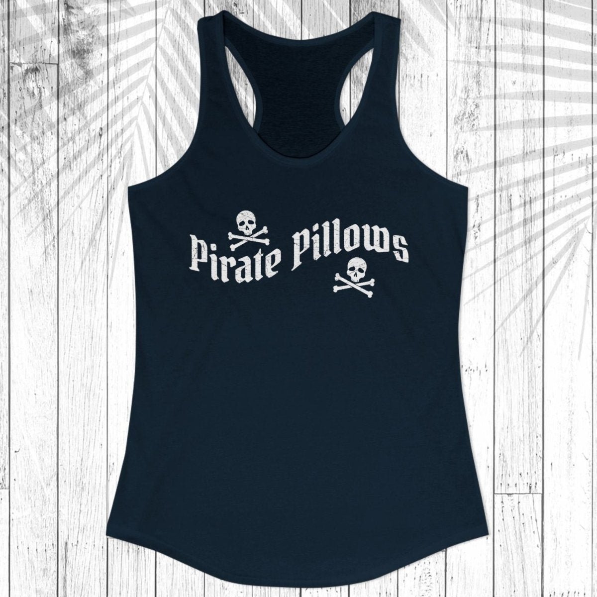 A navy blue racerback tank top with a white graphic of two skeletal hands forming a heart shape on the chest, displayed flat against a white wood plank background with a leaf shadow overlay.