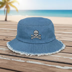 Blue denim bucket hat with embroidered text and graphics on a beachside boardwalk