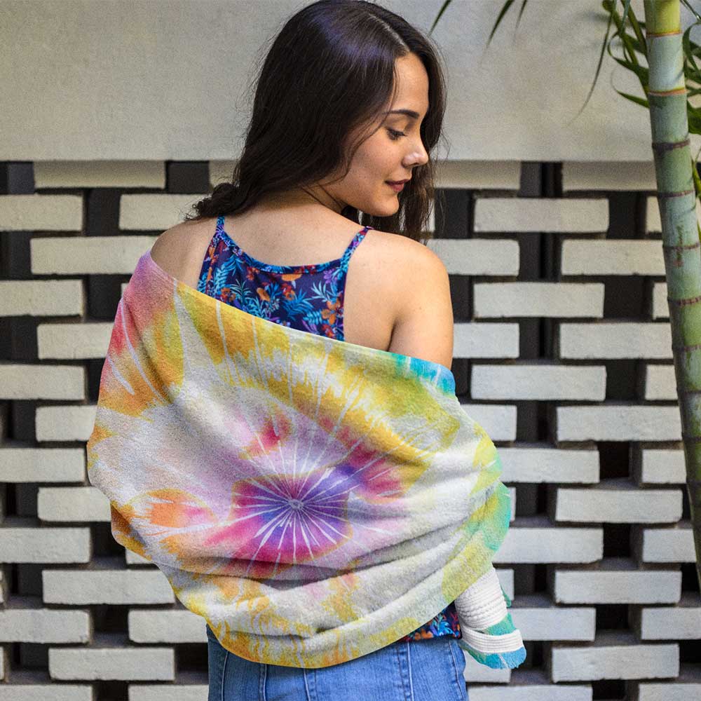 Girl wrapped in tie-dye beach towel adorned with sharks