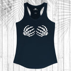 A navy blue racerback tank top with a white graphic of two skeletal hands forming a heart shape on the chest, displayed flat against a white wood plank background with a leaf shadow overlay.