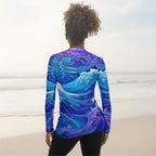 Person wearing a long-sleeve shirt with a blue and purple wave pattern on a faded beach background