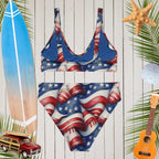 American flag swimsuit on a wooden background with beach accessories.