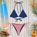 Nautical-Americana-themed bikini set with star and stripe design on a wooden background with beach elements.