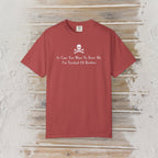 A red short-sleeve crewneck t-shirt with a white skull and crossbones graphic and the text 'In Case You Want To Scare Me I'm Terrified Of Boobies' printed on the chest, displayed flat on a rustic light wood background.