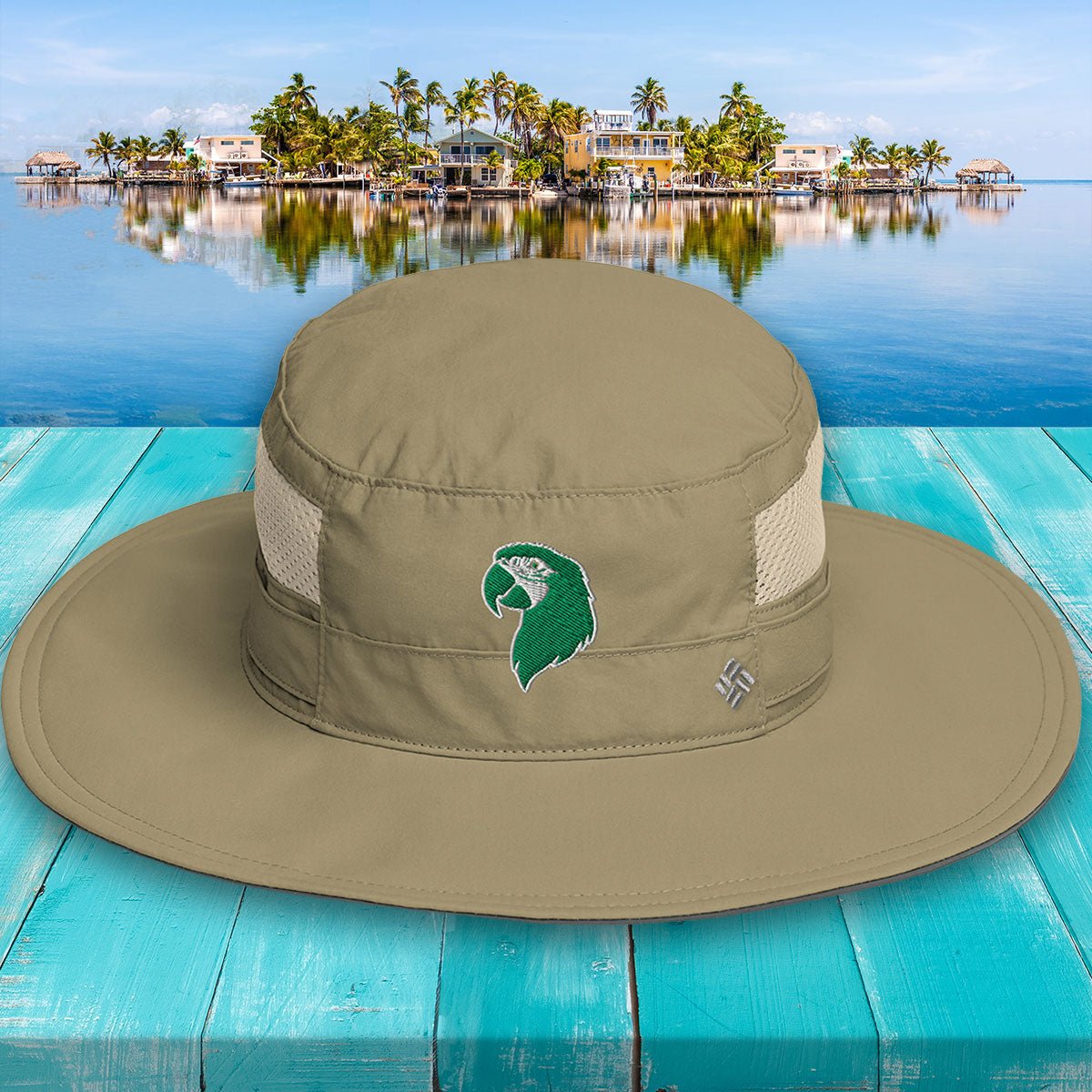 Khaki wide-brimmed hat with a logo on a turquoise wooden surface with a scenic background.