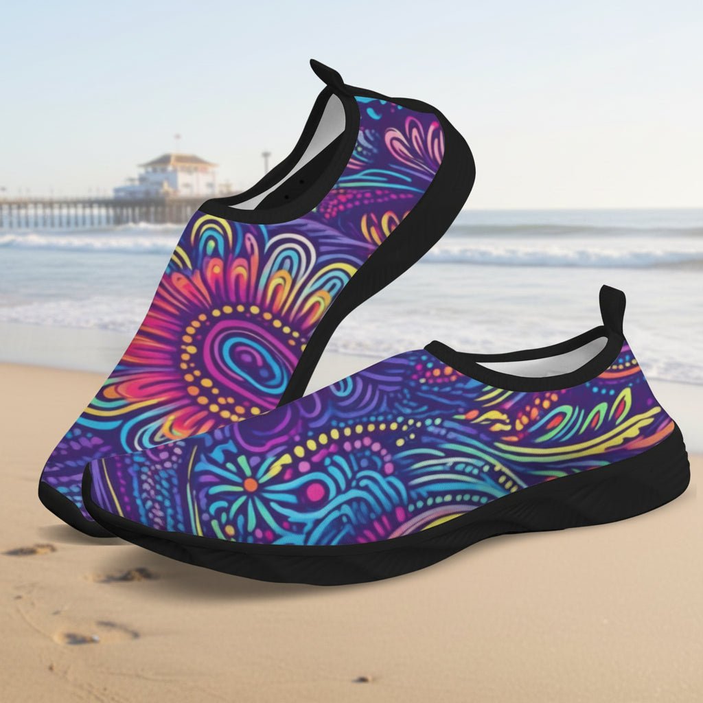 A pair of slip-on water shoes with a vibrant, multicolored psychedelic Tribal pattern on a white background.