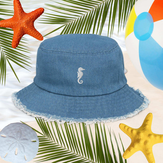 Sea Horse Jean Bucket Hat with embroidery, surrounded by beach elements like starfish and beach ball.