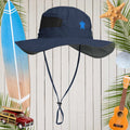 Navy blue sun hat with a sea turtle logo on a wooden background with beach-themed items.