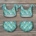 Four-piece swimsuit set with turtle pattern on a rustic wood background