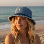 beautiful model wearing blue bucket hat with a sea horse emblem on a tropical beach