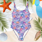 one-piece womens bathing suit with colorful seashell pattern over a beachy backdrop