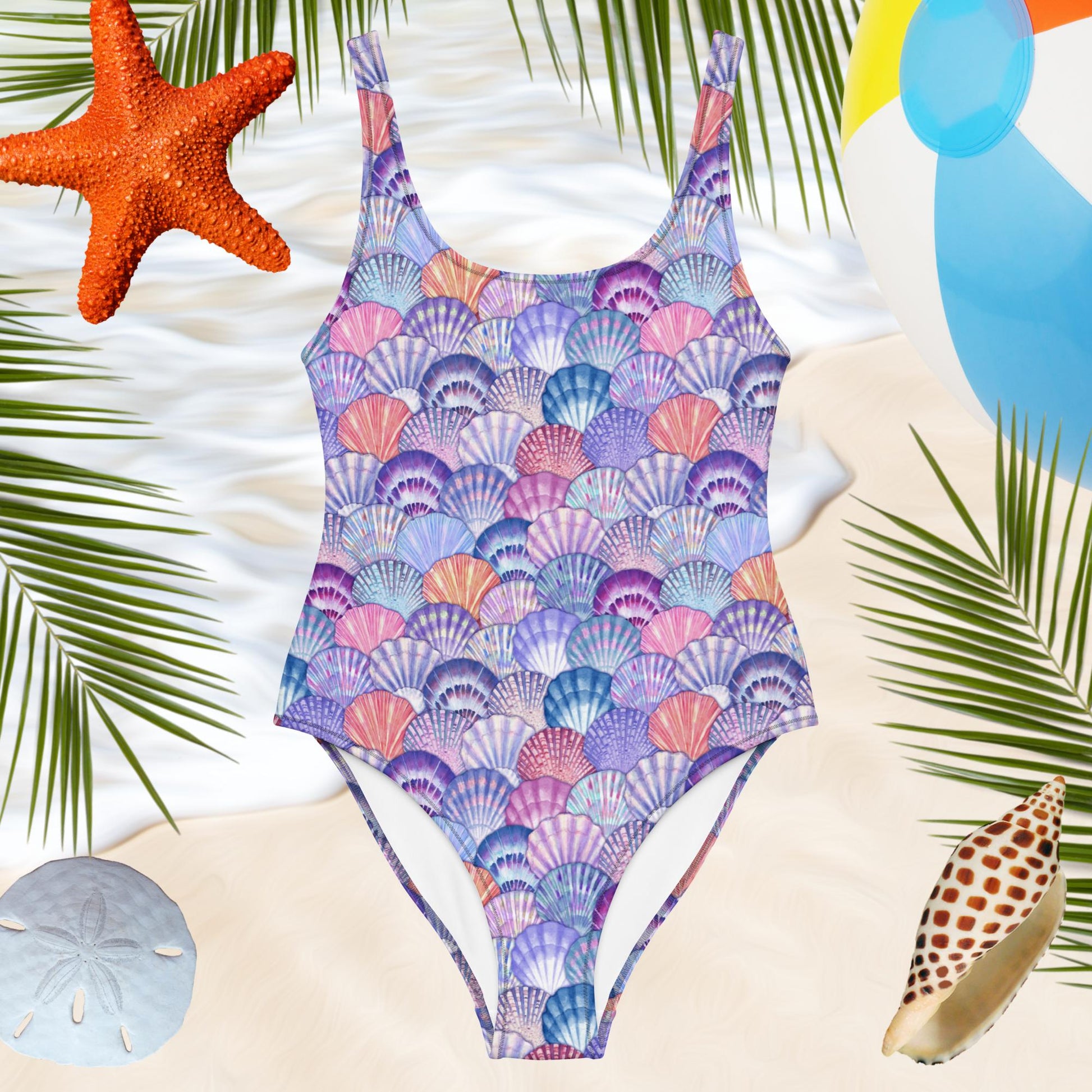 one-piece womens bathing suit with colorful seashell pattern over a beachy backdrop