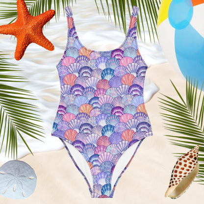 one-piece womens bathing suit with colorful seashell pattern over a beachy backdrop